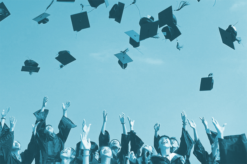 Happy graduates tossing caps into the air