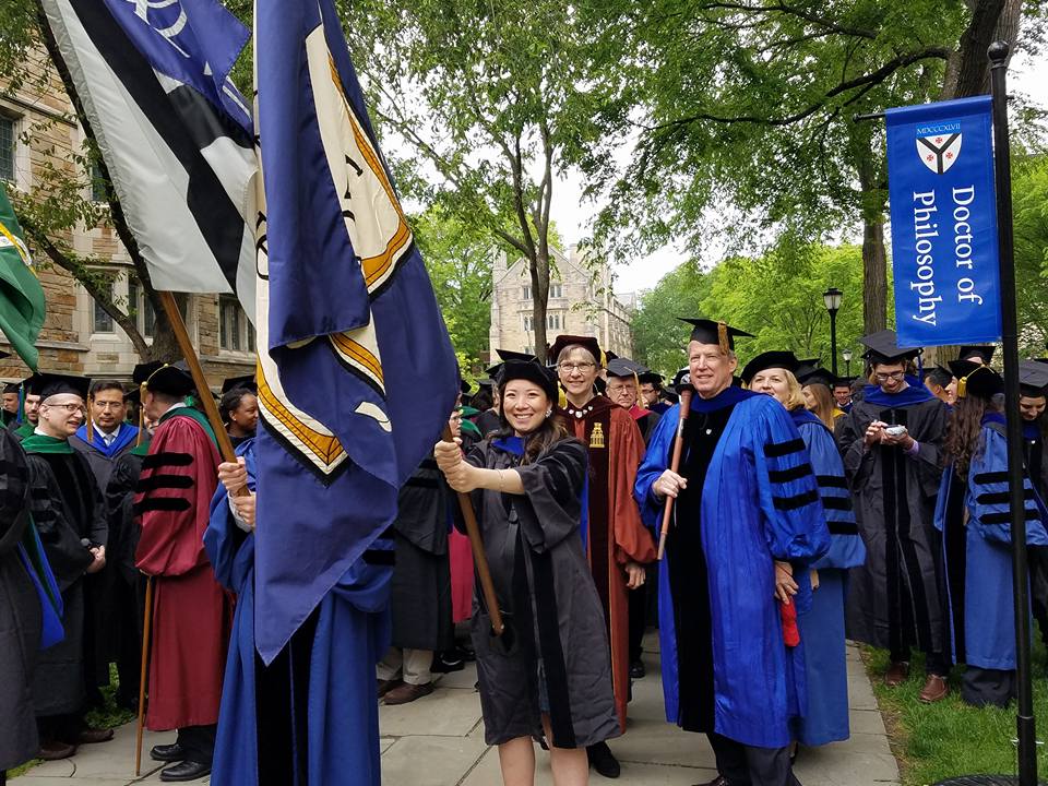 Graduation of Yale School of Arts students and someone is holding a flag