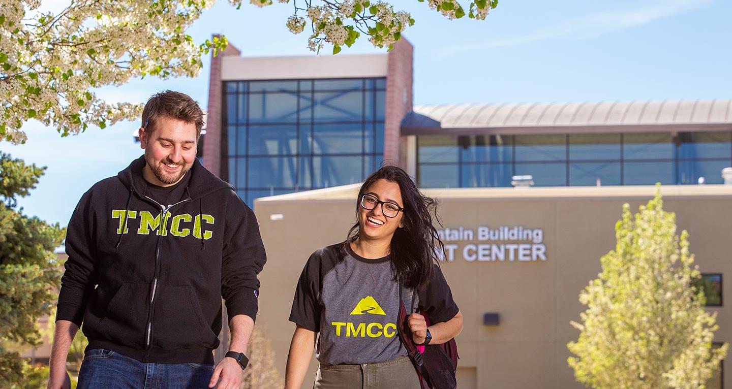 TMCC lizard mascot smiling and waving on campus