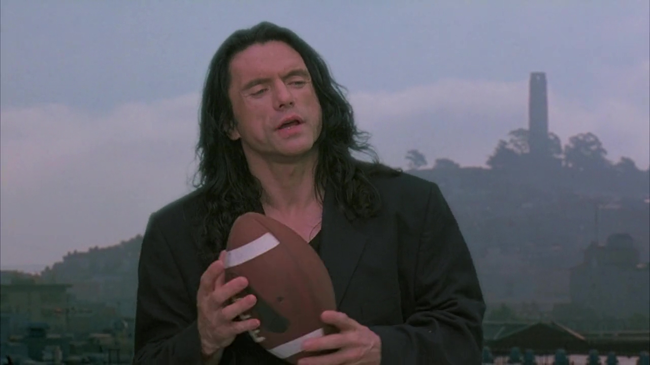 wiseau holding football