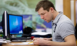 A student sitting at a computer in a classroom