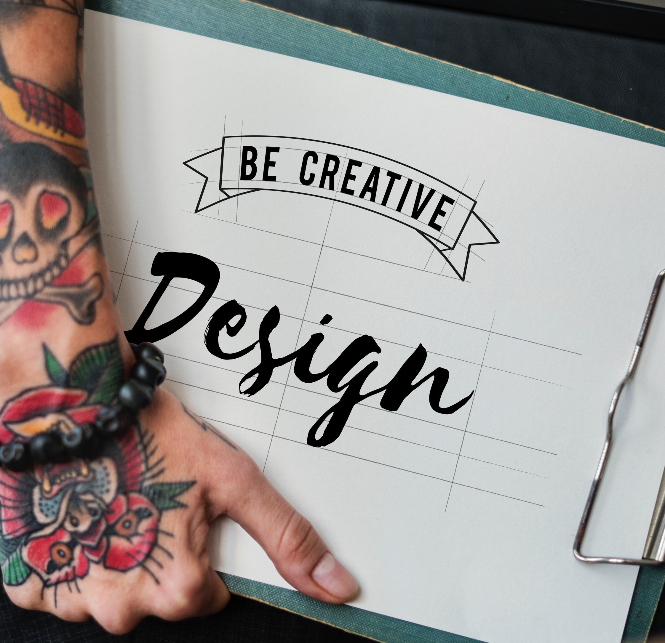 'Be Creative Design' typography on clipboard