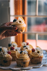 image of someone holding lemon cupcake