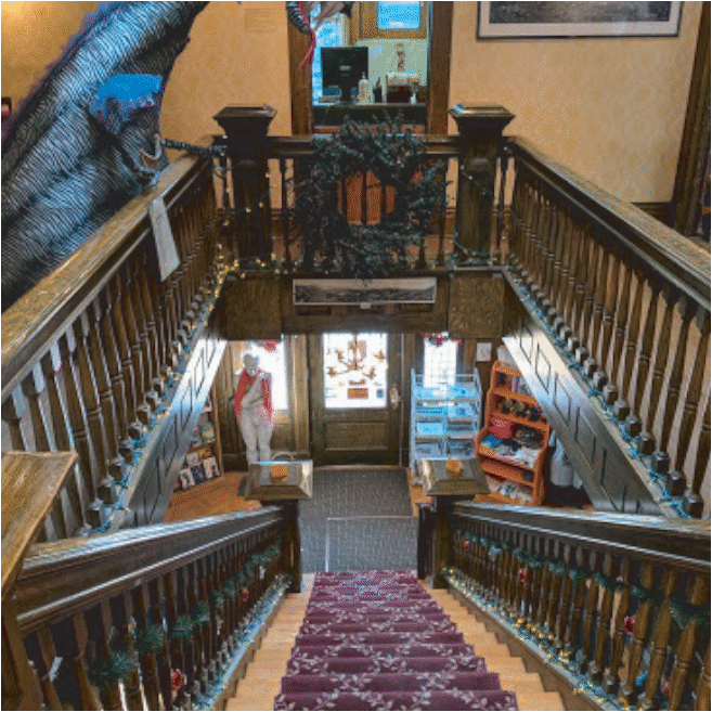 An interior shot of the store is shown. It is taken from the second story looking down the stairs to the front entrance.