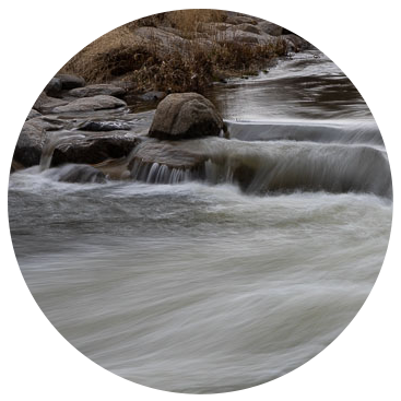 a close up image of water flowing over rocks in a river