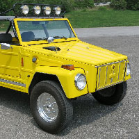 a yellow volkswagen thing parked pretty on asphalt