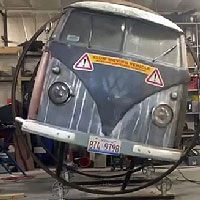 mechanic working on volkswagen split window bus with a lovely patina