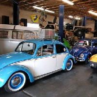 interrior of a volkswagen repair shop with several vehicle projects progressing all at once