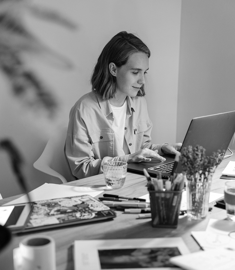 person who is also working at their desk but with a nice little smile possibly done working on their project