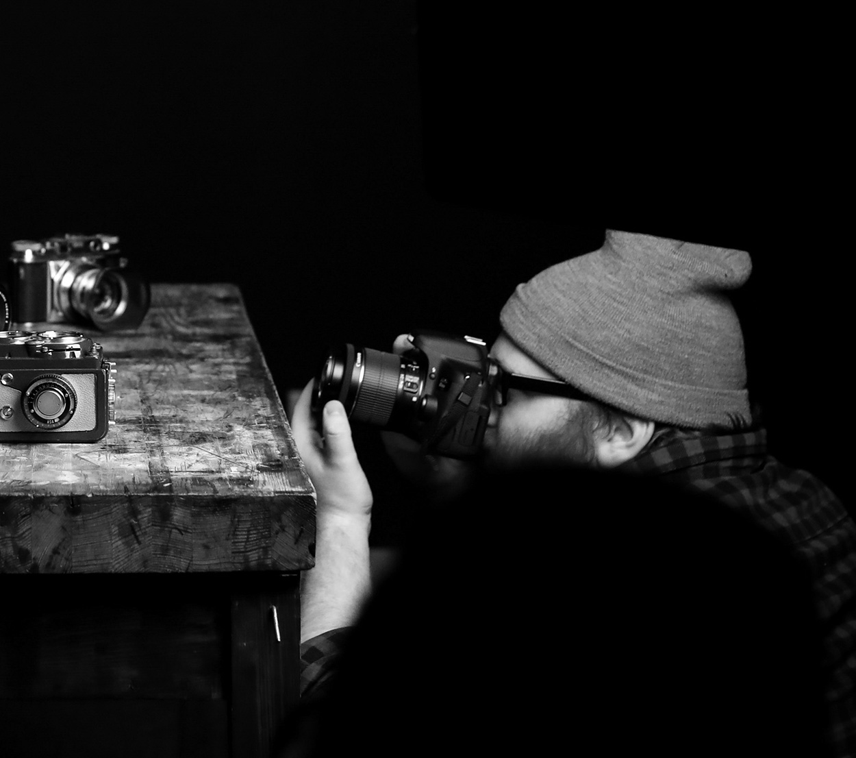 man taking pictures of other cameras for a class